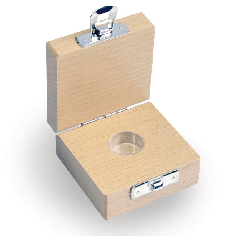 Holz Etui auf weißem Hintergrund. Das Etui ist aufgeklappt und weißt im unteren Teil eine einzige runde Vertiefung zum platzieren eine Milligrammgewichtes. Auf der Vorderseite ist das Etui mit einem Scharnier versehen zum sicheren Verschließen des Etuis.