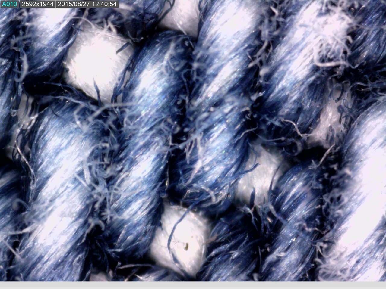 AM7115MZTL - Makroaufnahme: Vergrößerte Ansicht blauer und weißer Faserstruktur mit feinen Härchen