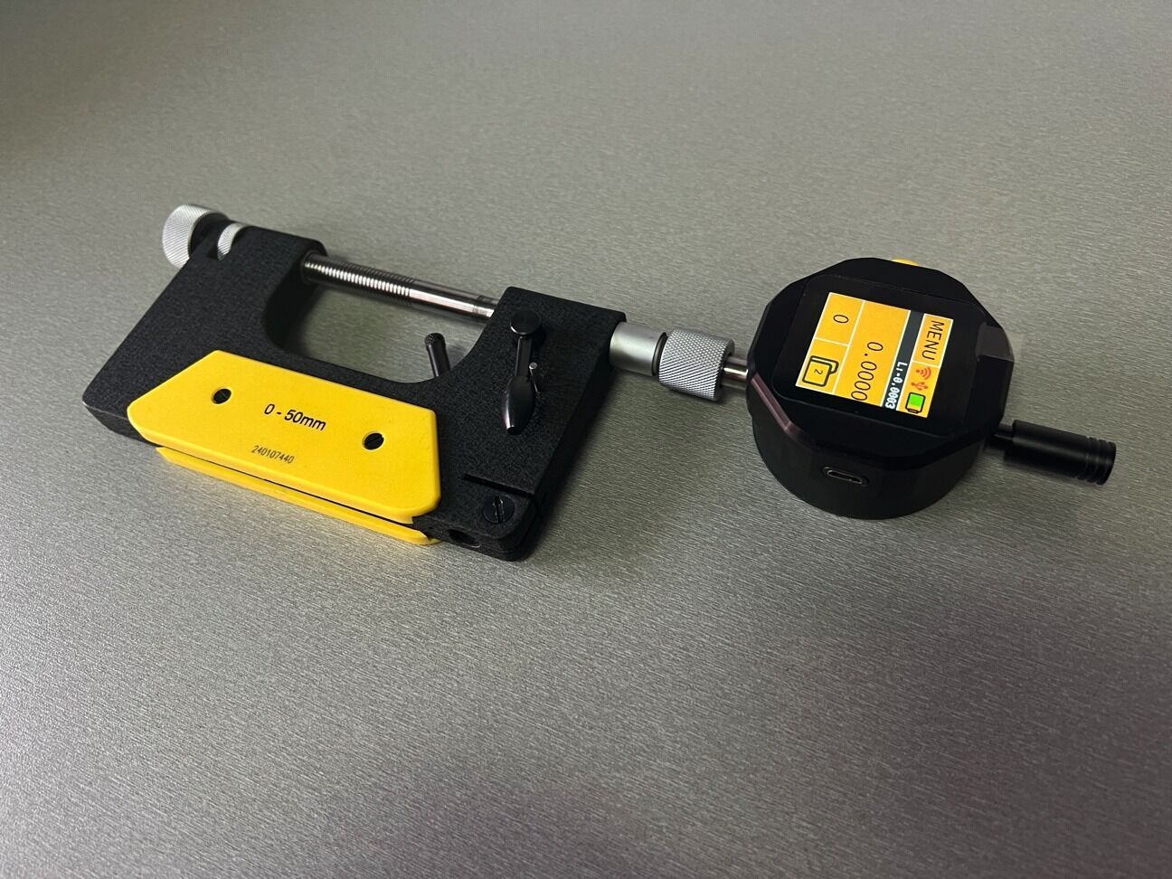 Microtech Digitale Bügelmessschraube 100-150mm: Schwarz-gelbes Gehäuse, Digitalanzeige, Wireless/USB, Schrägansicht