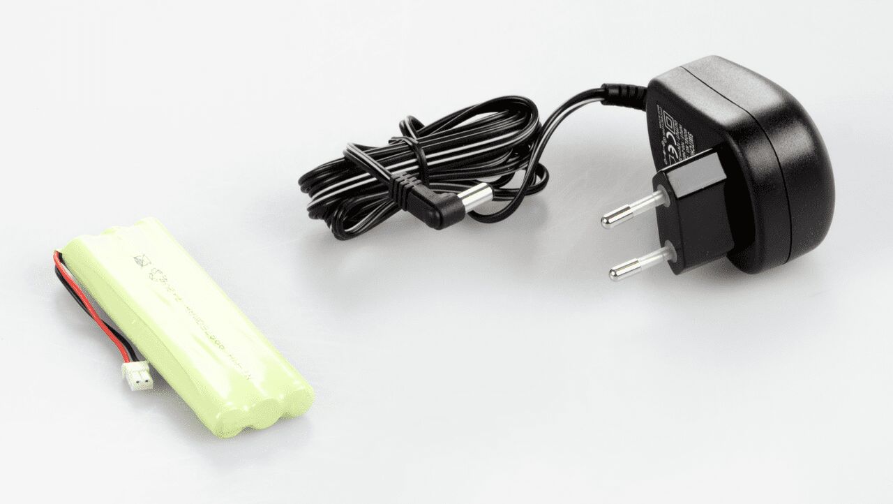 Akkubetrieb Set zum Einbau in die Waage auf weißem Hintergrund. Das Set besteht aus Batterien die in hellgrüner Plastik eingeschweißt sind und einem Stecker mit aufgefaltetem Kabel.