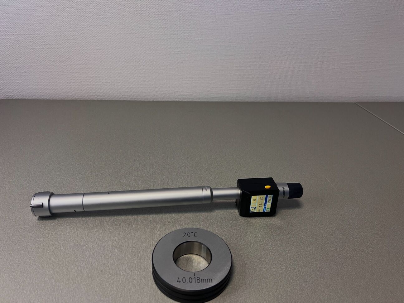 Microtech Metrology 100mm Drei-Point Innenmessschraube, silber, mit Display, und Einstellring. Frontalansicht.