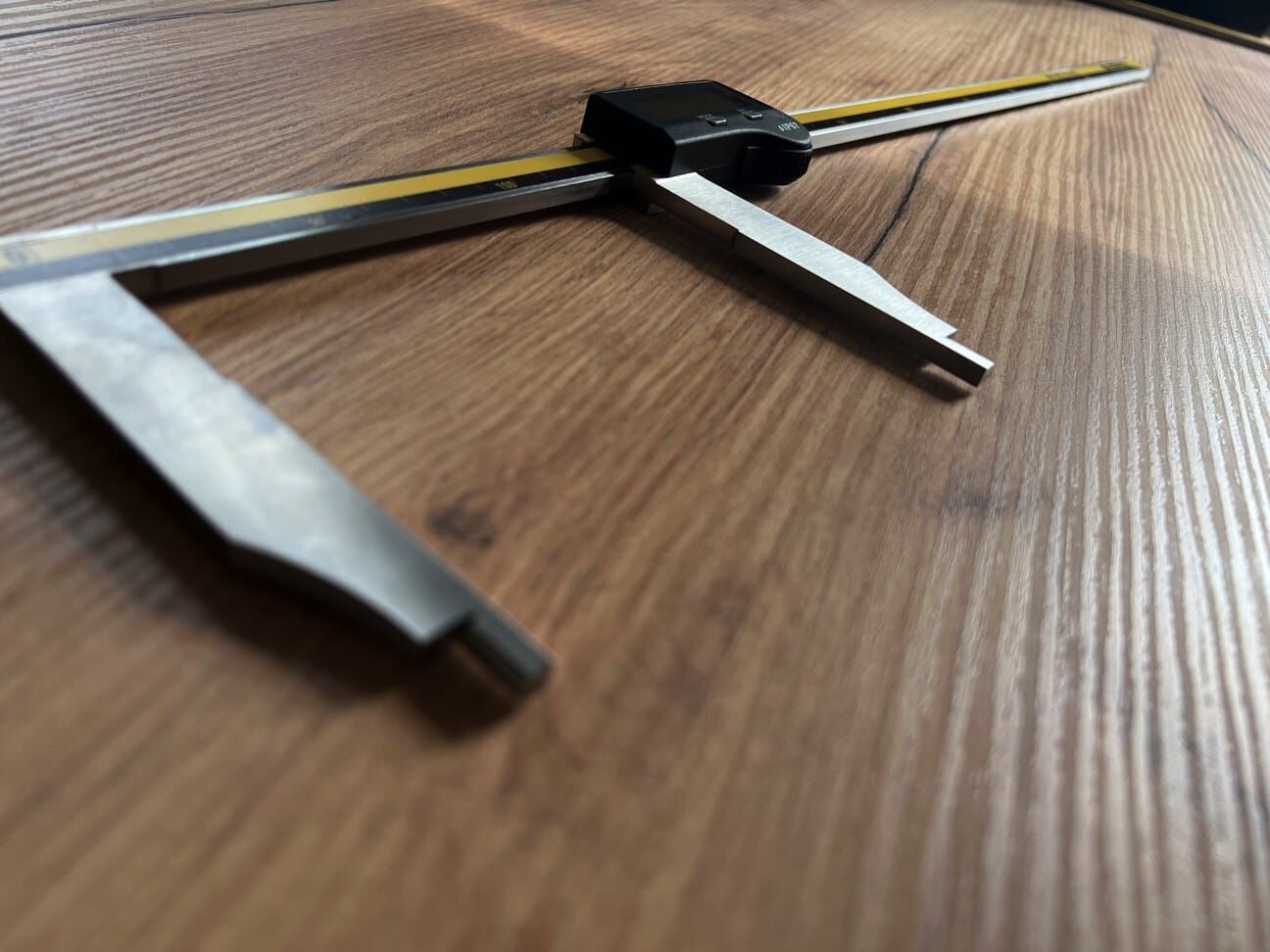 Microtech Metrology 500mm Digitaler Messschieber: Lange Messschnäbel aus Metall in Schrägansicht auf Holzoberfläche