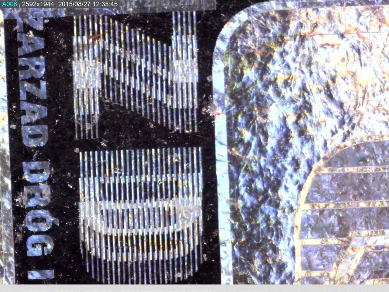 Dino-Lite AM7115MZTL: Hologrammetikett mit Polarisationseffekt, helle Linien auf dunklem Hintergrund