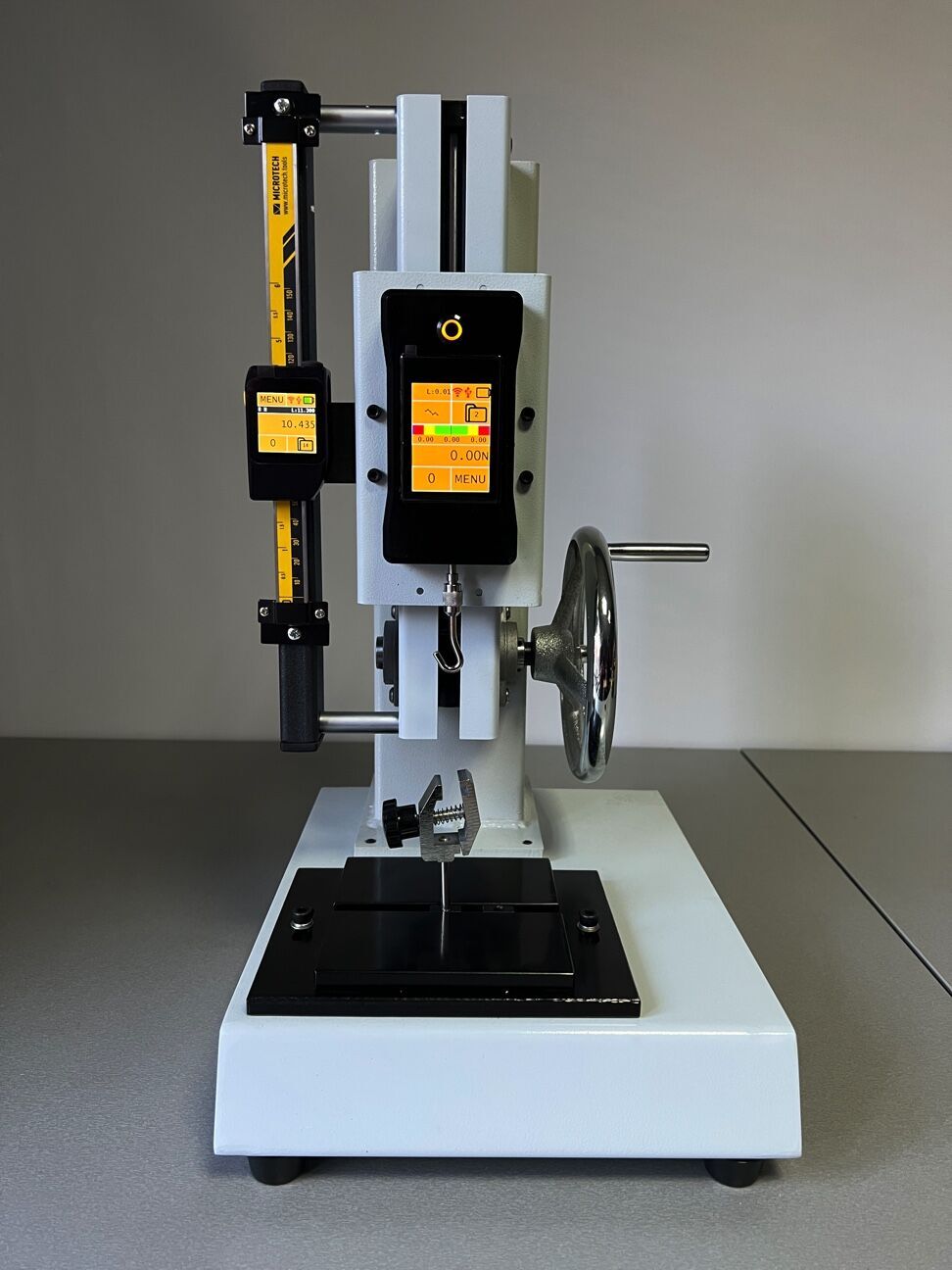 Microtech Teststand Digital: Weiß-grauer Korpus, gelbes Lineal, zwei digitale Displays in Frontansicht