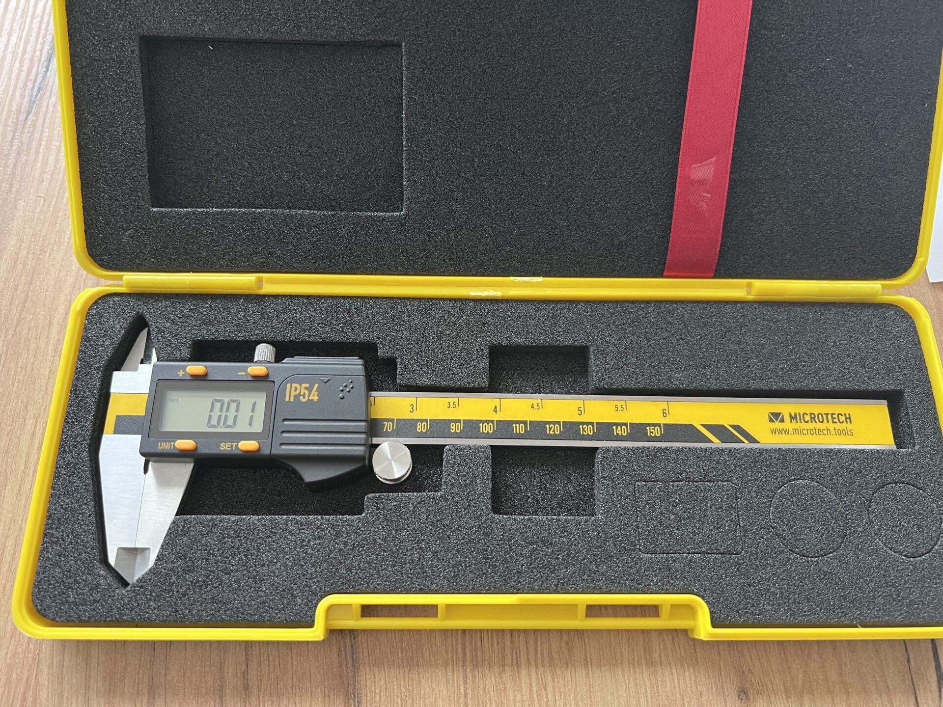 Microtech Digital-Messschieber 300mm: Gelber Koffer, schwarze Schaumstoffeinlage, grauer Messschieber mit LCD-Display, Ansicht von oben
