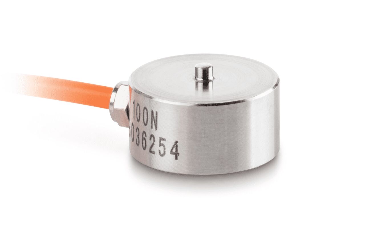 Miniatur Knopfmesszelle auf weißem Hintergrund.  Die Zelle ist rund und hat einen kleinen Stab der auf der Oberseite absteht. Aus der Seite ragt ein orangenes Kabel.